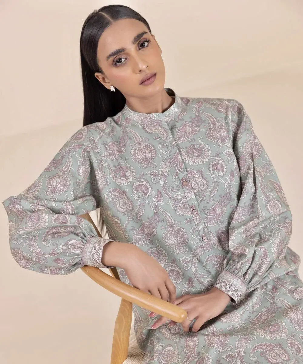 Seated model in a sage printed cambric suit